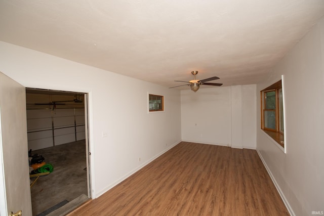 spare room featuring ceiling fan, baseboards, and wood finished floors