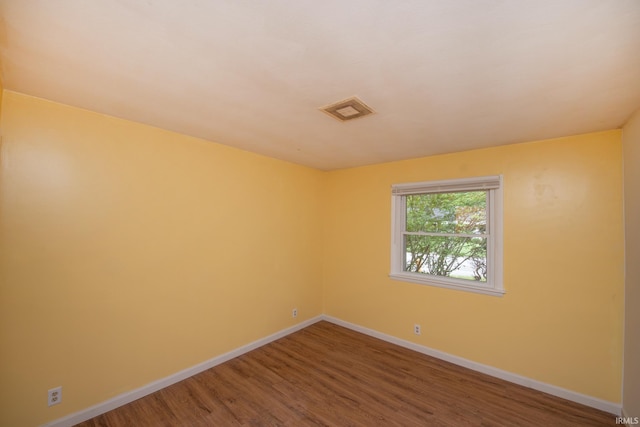 unfurnished room with visible vents, baseboards, and wood finished floors