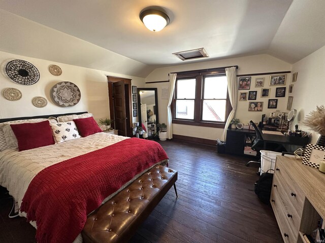 bedroom featuring lofted ceiling, dark wood finished floors, attic access, and baseboards