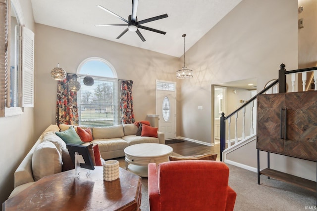 carpeted living room featuring stairs, high vaulted ceiling, a ceiling fan, and baseboards