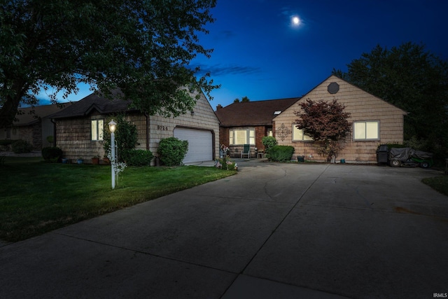 ranch-style house featuring a garage, driveway, and a lawn