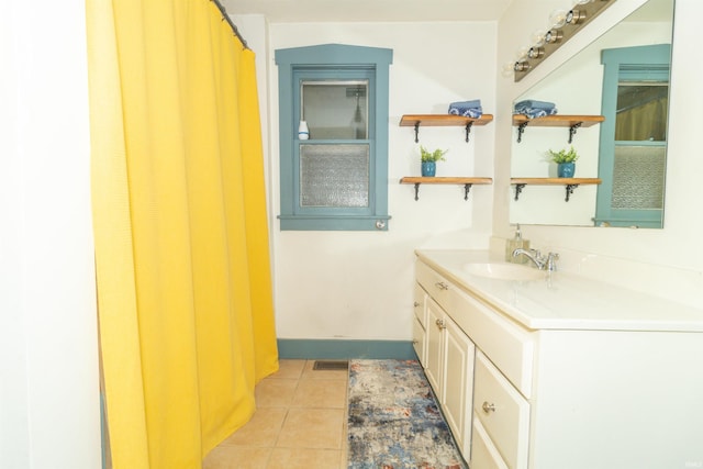 bathroom with visible vents, vanity, baseboards, and tile patterned floors