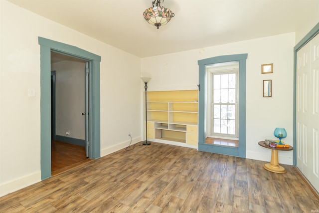 unfurnished room with baseboards and wood finished floors