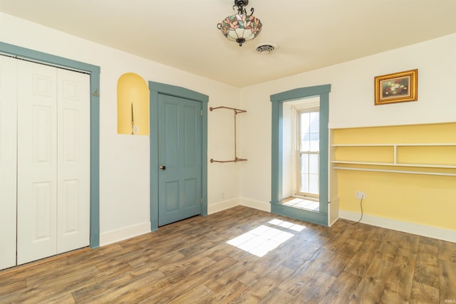 interior space featuring wood finished floors, visible vents, and baseboards