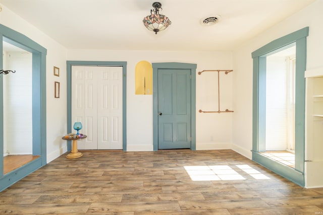 entrance foyer featuring wood finished floors, visible vents, and baseboards