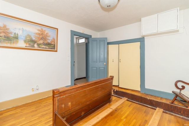 bedroom featuring a closet, baseboards, and wood finished floors