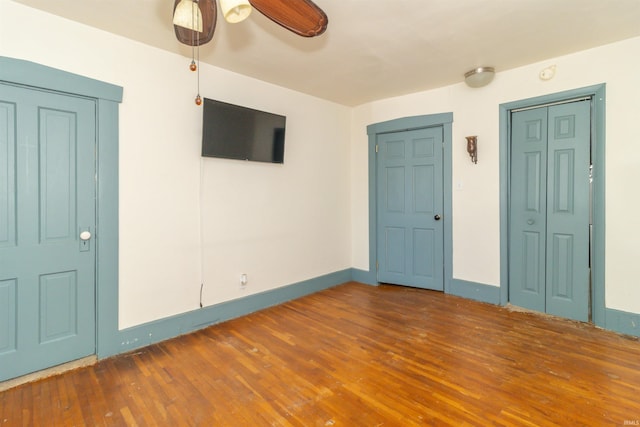 empty room with baseboards, a ceiling fan, and wood finished floors