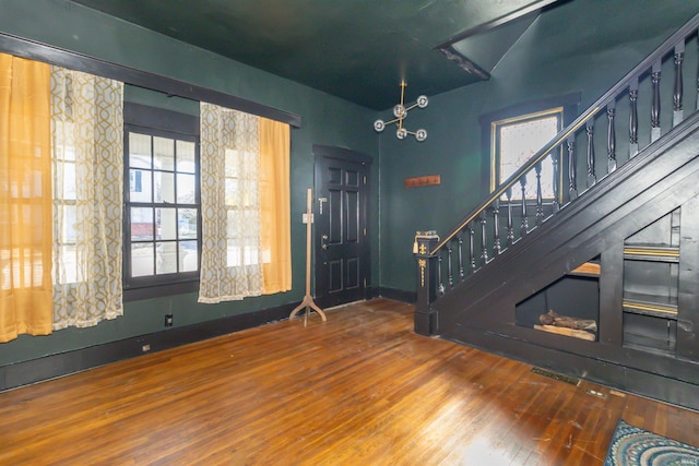 foyer entrance with stairway, baseboards, and wood finished floors