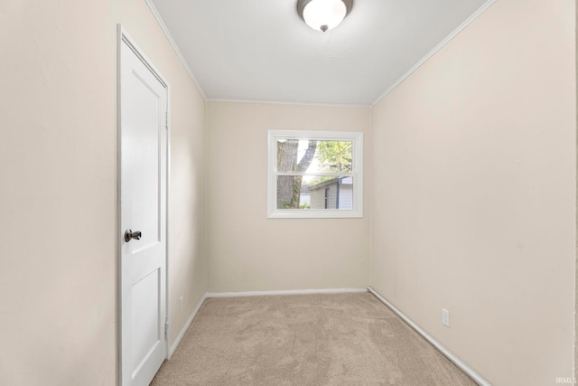 unfurnished room with ornamental molding and light colored carpet