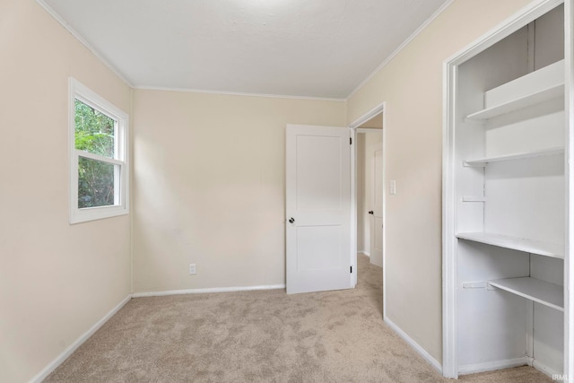 unfurnished bedroom featuring carpet, ornamental molding, and baseboards