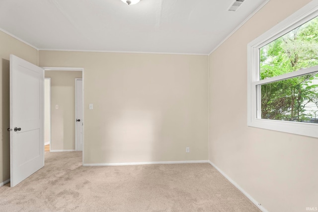 unfurnished room featuring baseboards, ornamental molding, visible vents, and light colored carpet