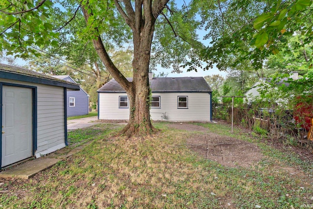 back of property with an outbuilding and fence