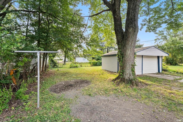 view of yard featuring a detached garage and an outbuilding