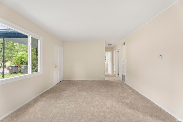 unfurnished room with baseboards, visible vents, and light colored carpet