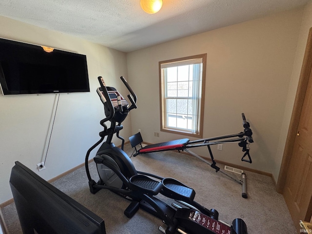 exercise area with a textured ceiling, carpet floors, visible vents, and baseboards