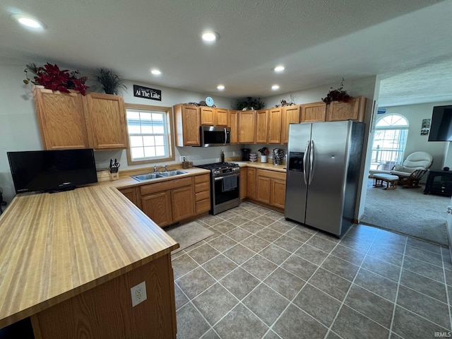 kitchen featuring stainless steel appliances, recessed lighting, light countertops, and a sink