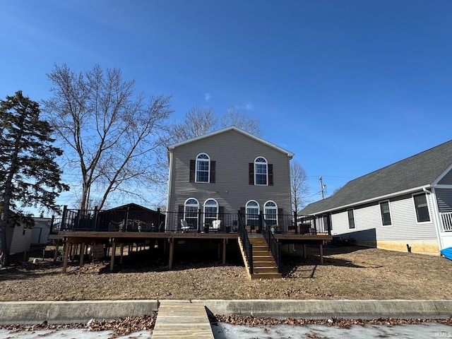 back of property with a wooden deck and stairs