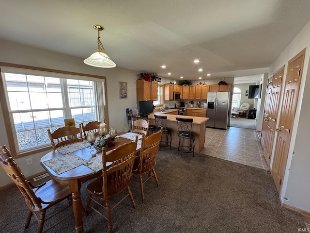 dining space with light carpet, light tile patterned floors, and recessed lighting