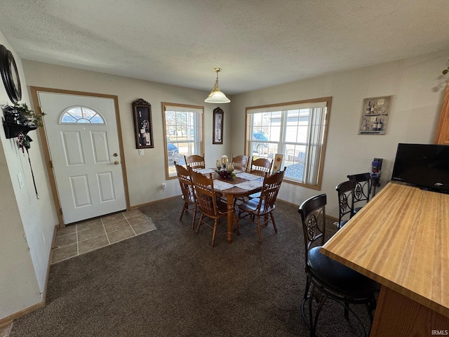 dining space featuring carpet, baseboards, and a textured ceiling