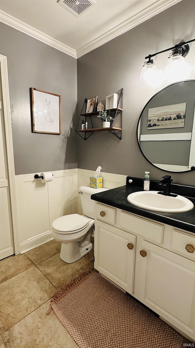 bathroom featuring toilet, vanity, visible vents, and ornamental molding