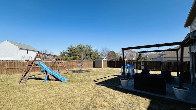 view of yard with a playground, an outdoor structure, a fenced backyard, and a storage unit