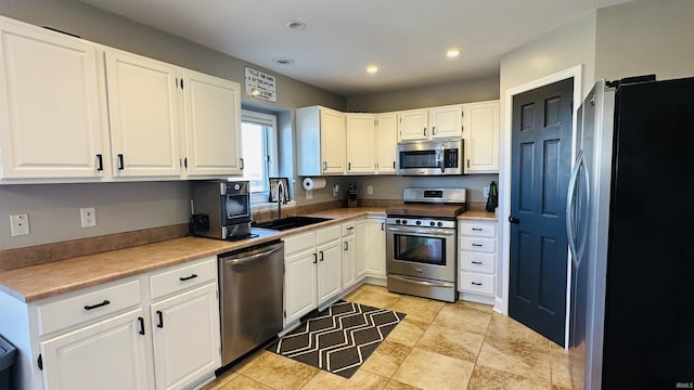 kitchen with stainless steel appliances, recessed lighting, a sink, and white cabinets