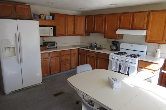 kitchen featuring visible vents, brown cabinetry, a sink, white appliances, and under cabinet range hood