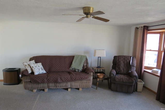 carpeted living room with a textured ceiling, a ceiling fan, and baseboards