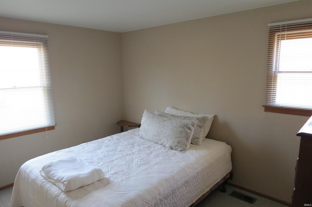 bedroom with multiple windows and visible vents