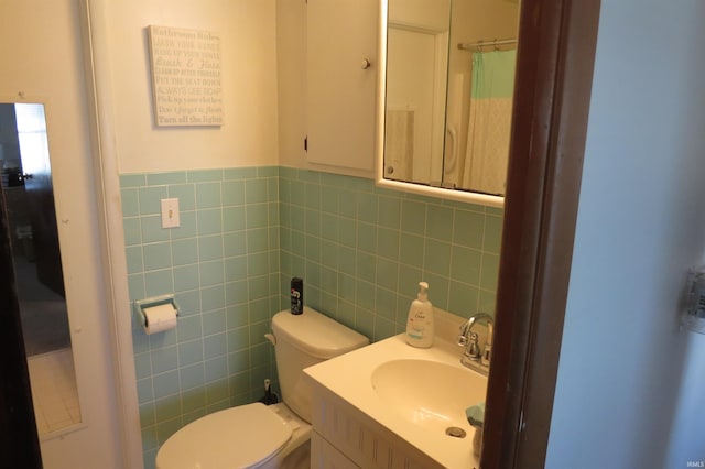 bathroom with curtained shower, tile walls, toilet, and vanity