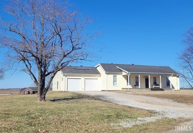 ranch-style house featuring driveway, an attached garage, a porch, and a front yard