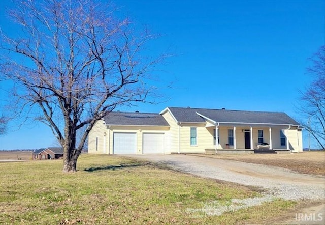 single story home with an attached garage, covered porch, dirt driveway, and a front yard