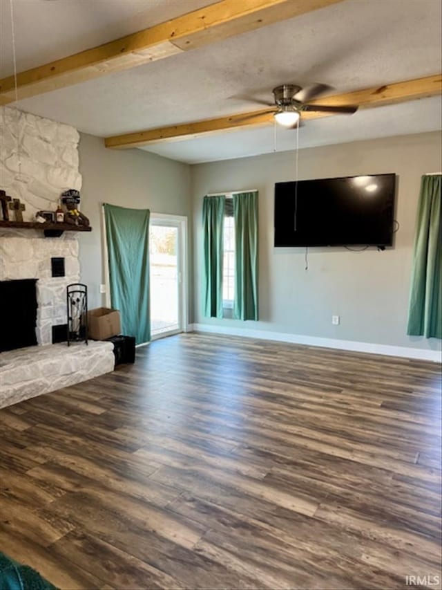 unfurnished living room featuring wood finished floors, beam ceiling, and baseboards