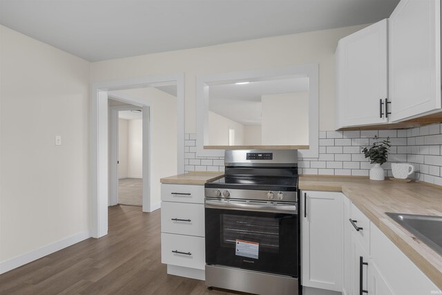 kitchen with dark wood-type flooring, a sink, white cabinets, stainless steel range with electric cooktop, and tasteful backsplash