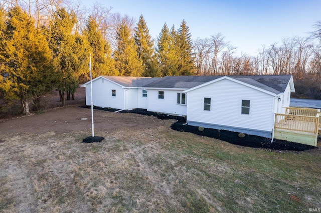 view of front facade with driveway, a front lawn, and a wooden deck