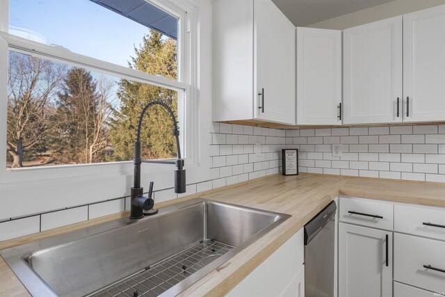 kitchen with dishwasher, a wealth of natural light, a sink, and wood counters