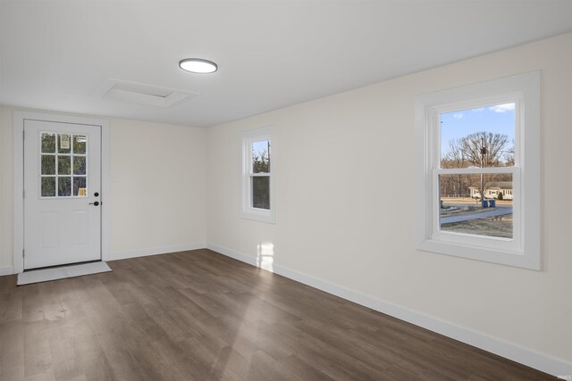 empty room with dark wood-style flooring, plenty of natural light, and attic access