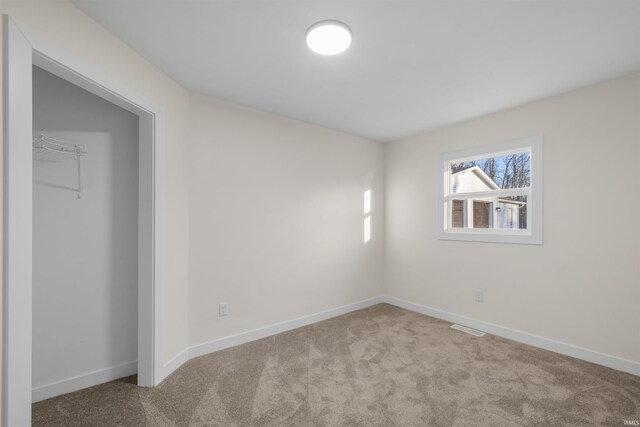 unfurnished bedroom featuring carpet floors, visible vents, and baseboards