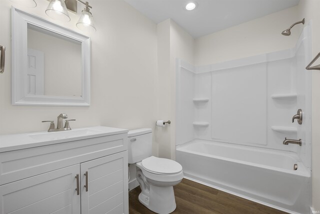 bathroom with shower / bathtub combination, vanity, wood finished floors, and toilet