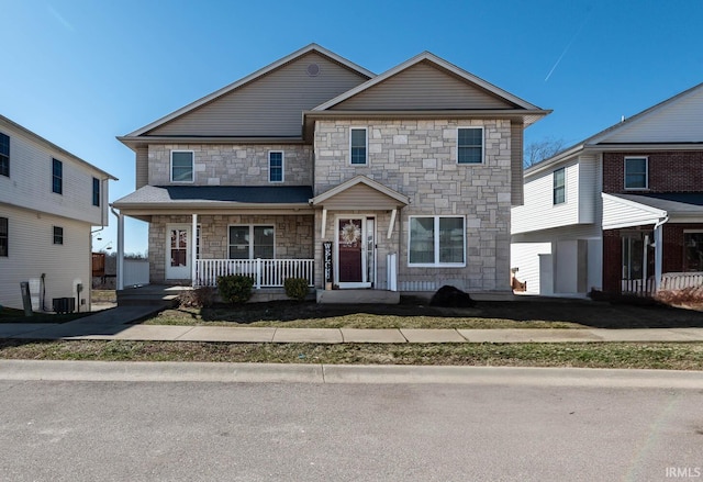 view of front of home featuring covered porch, stone siding, and central AC unit