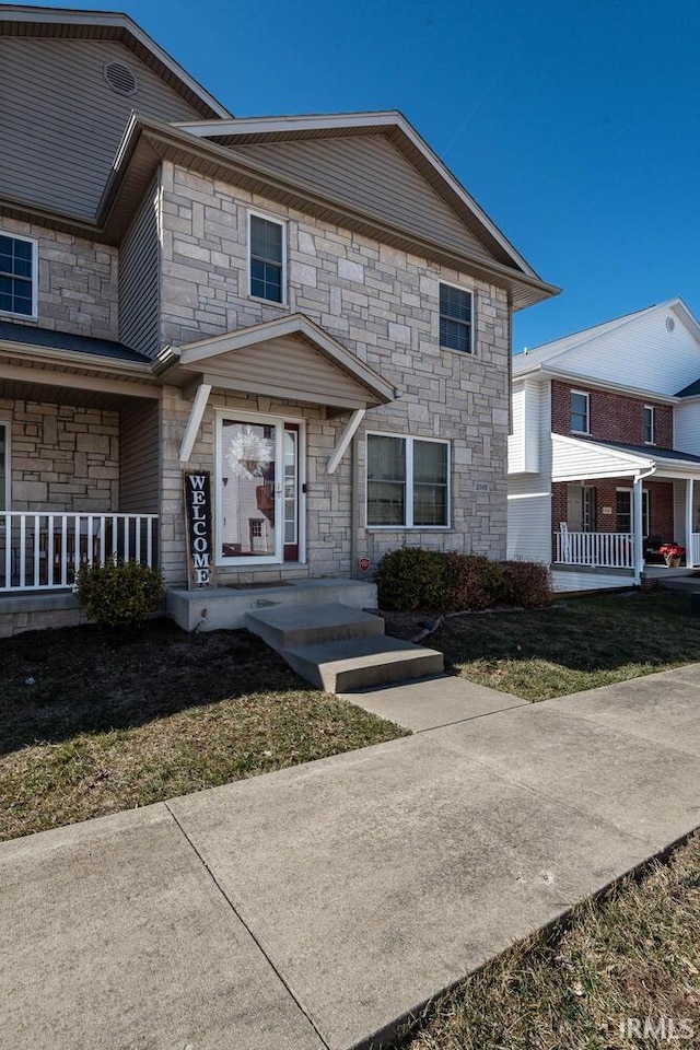 view of front of property featuring stone siding and a porch