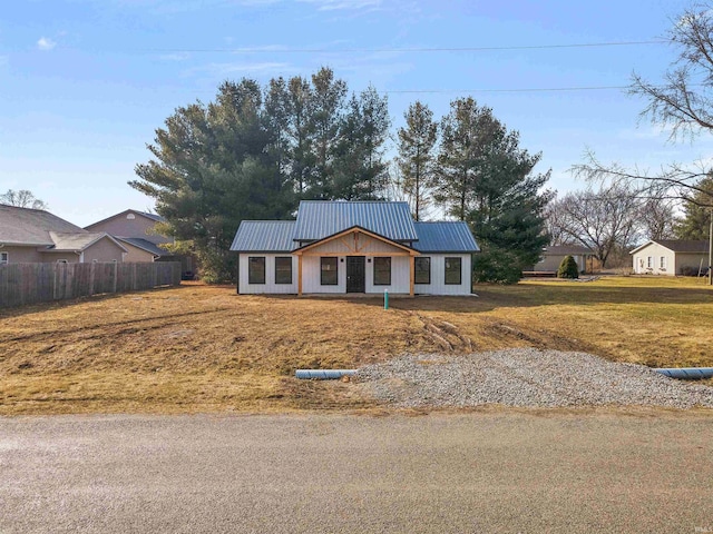 view of front of property with a front lawn, fence, and metal roof