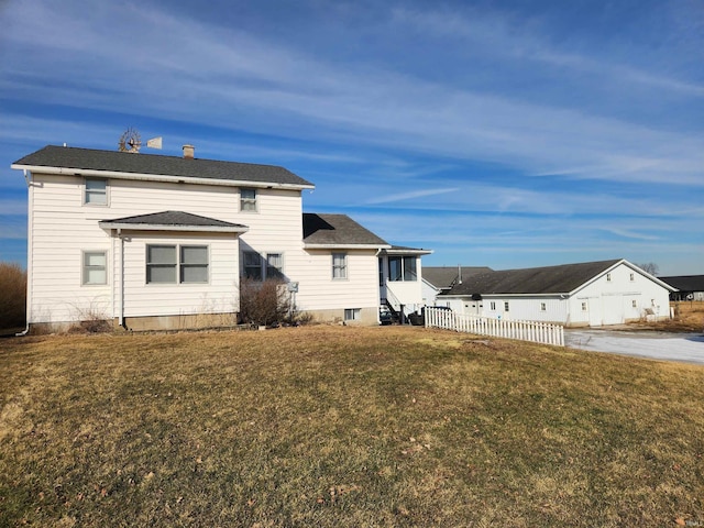 rear view of property featuring a lawn