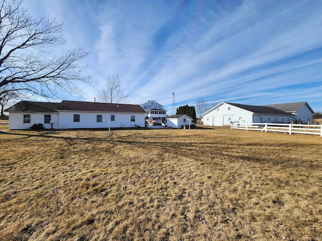 back of property featuring a yard and fence