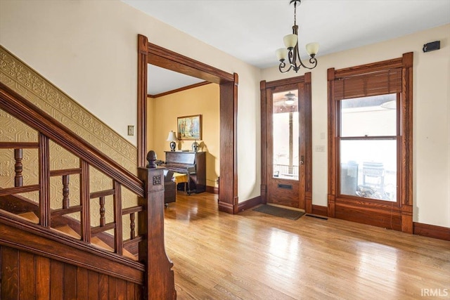 entryway featuring visible vents, light wood-style flooring, an inviting chandelier, and stairs