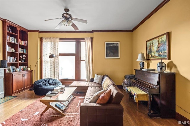 living room featuring ceiling fan, baseboards, wood finished floors, and crown molding