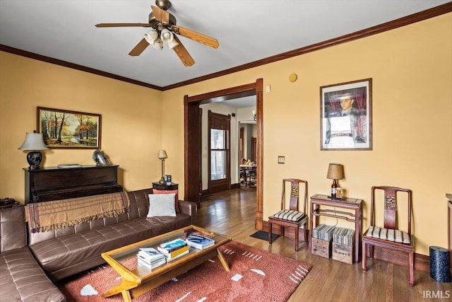 living room with ceiling fan, wood finished floors, and crown molding