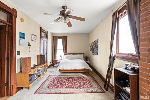 bedroom with a ceiling fan, light colored carpet, and baseboards