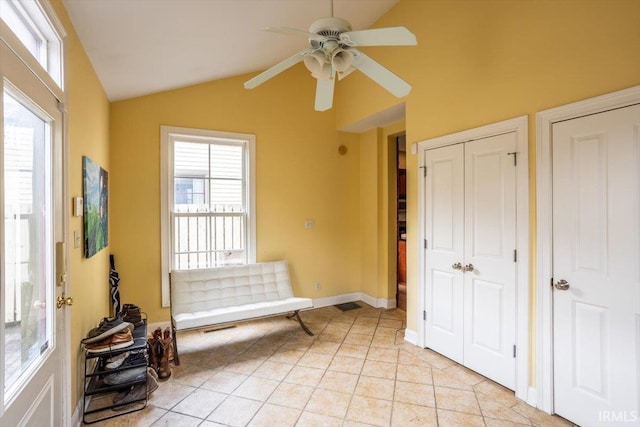 sitting room featuring a ceiling fan, vaulted ceiling, baseboards, and light tile patterned floors