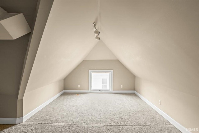 bonus room featuring lofted ceiling, carpet, and baseboards